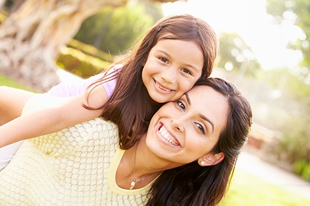 Una madre y su hija con una amplia sonrisa