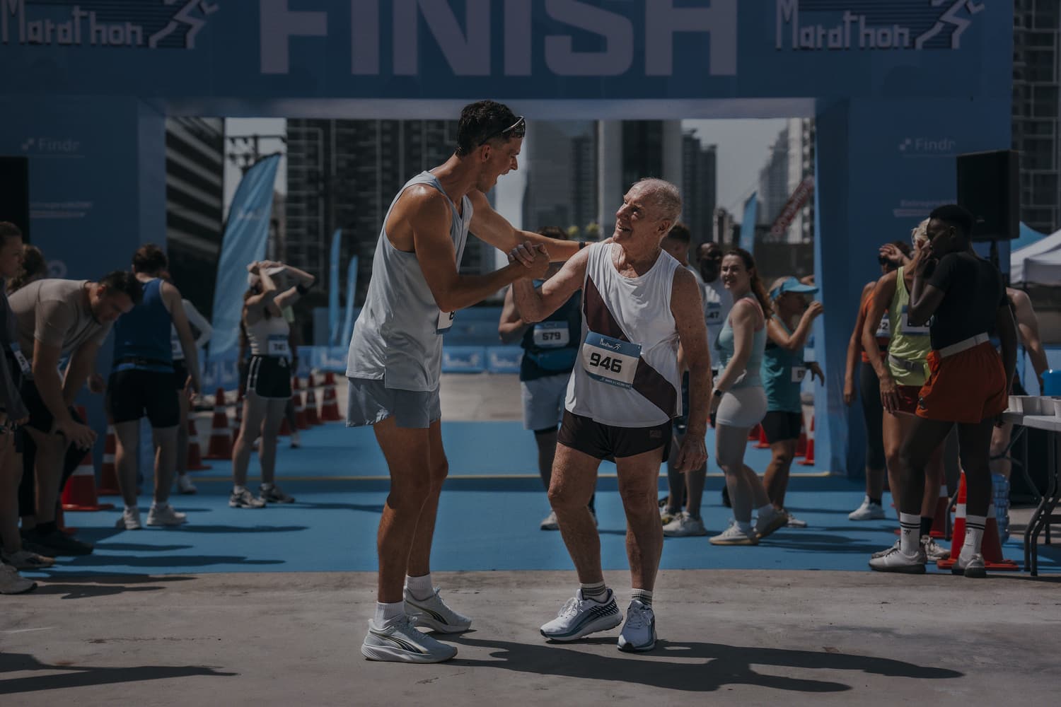 Fotografía de dos atletas de diferentes generaciones felicitándose al acabar una carrera
